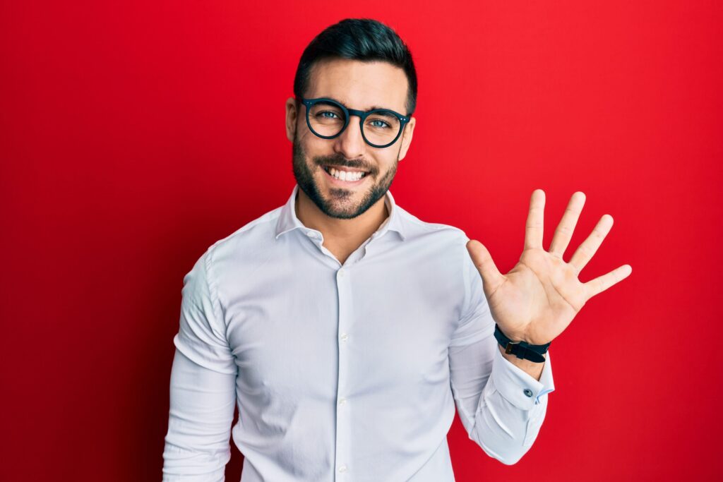 Man holding up five fingers against a red background